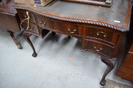 An early 20th Century mahogany lowboy style desk having leather inset, gadrooned edge on cabriole