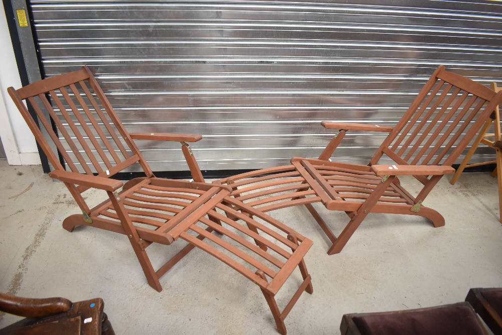 A pair of teak steamer style sun loungers