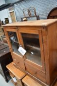 An interesting composite low shallow cabinet having glazed shelf section over two drawers ,