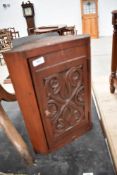 A 19th Century stained frame corner cupboard of small proportions having carved door