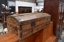 A vintage dome top trunk of low design, covering worn, bears shipping labels (railways) , width