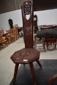 An Arts and Crafts spinning chair, having floral carving to seat and back rest, possibly Welsh