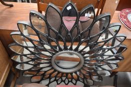 A large composite wall mirror, of floral form, width approx 100cm