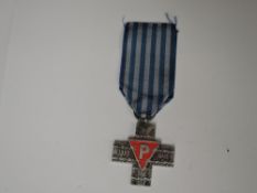 A Polish Auschwitz Cross medal 1939-1945, on reverse translated to ‘From citizens of the Polish
