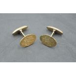 A pair of 9ct gold cufflinks having oval textured panels with bar connectors, approx 7.1g