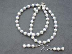 A string of cultured pearls with rough cut tanzanite spacers and matching drop earrings all having