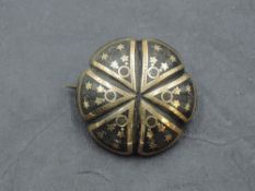 A tortoise shell brooch of circular cushion form having yellow metal piquet work decoration