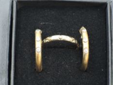 A pair of 9ct gold hoop earrings having an inset trio of paste stones, and a 9ct gold wedding