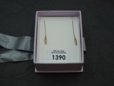 A pair of 10k yellow metal drop earrings, the faceted rice grain drops suspended by a fine linked