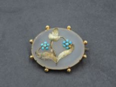 A Victorian oval gilt metal mounted agate brooch, with foliate turquoise set decoration, 4cm,