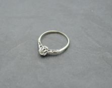 A diamond solitaire ring of dainty form, approx 0.25ct in a raised claw mount having diamond set