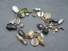 A gilt metal charm bracelet/necklace, suspended with a variety of charms, to include a bog oak