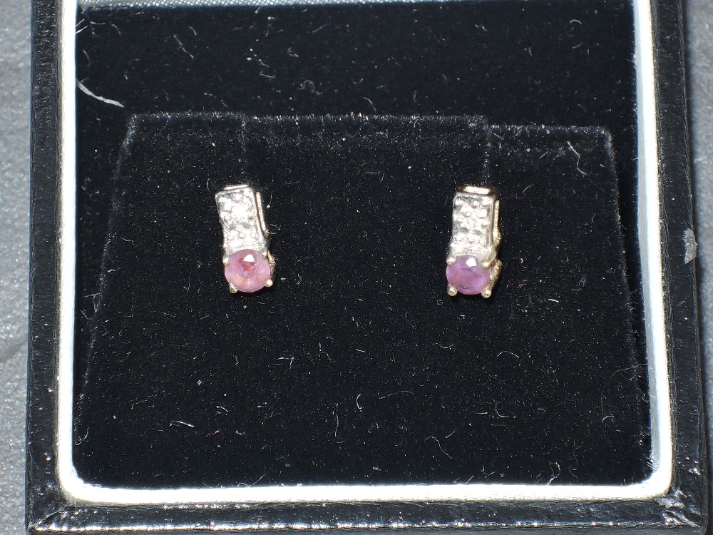 A pair of diamond chip and amethyst stud earrings in 9ct gold mounts, approx 1g