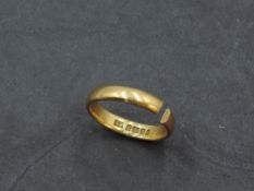 A 22ct gold wedding band, marked 22, shank split, 3.2grams.