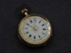 A small yellow metal top wound pocket watch having Roman numeral dial on decorative face in