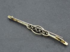 A yellow metal bar brooch stamped 15ct having five central blue topaz in collared mounts within a