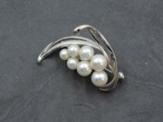 A 14 carat white gold and cultured pearl brooch of stylised form, approx 9.7g