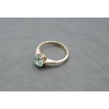 An aquamarine solitaire ring in a claw set mount on a yellow metal loop stamped 15ct, size N &