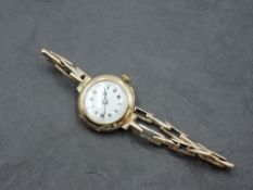 A lady's vintage 9ct gold wrist watch having Roman numeral dial to white enamelled face in plain