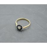 A sapphire and diamond chip cluster dress ring on a yellow metal loop stamped 18ct, size N/O & 2.4g