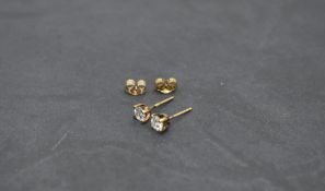 A pair of 9ct gold solitaire stud earrings, one having a diamond, approx 0.3ct, the other having a