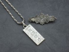 A silver ingot pendant having oversized Silver Jubilee (1977) hallmarks and engraved decoration on a