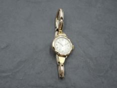 A vintage 9ct gold wrist watch having Arabic numeral dial with gilt minute dots to circular white