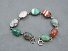 A mixed agate bracelet having nine agate cabochon stones in white metal mounts with chain