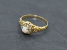 A Victorian opal and diamond cluster ring having central opal cabochon within a surround of rough