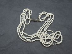 A four string necklace of baroque seed pearls with white metal box clasp, approx 16'