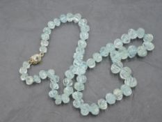 A string of carved aqua marine style beads with 9ct gold clasp, approx 20'