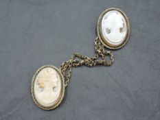 A conch shell cameo duo brooch depicting maidens in profile in yellow metal decorative mounts