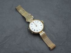 A vintage 9ct gold wrist watch having Roman numeral dial to circular white enamel face on a woven