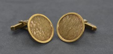 A pair of yellow metal cufflinks stamped 333, having circular panels with textured decoration and
