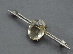 A white metal bar brooch stamped silver having a large central oval citrine of pale colour