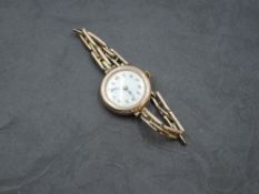 A lady's vintage 9ct rose gold wrist watch having Arabic numeral dial to white face with yellow