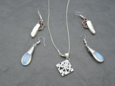 A silver pendant of pierced square form and two pairs of silver drop loop earrings having moonstone,