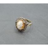 A cameo ring depicting a maiden in profile in a decorative mount on a yellow metal loop stamped 9ct,