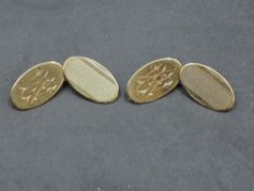 A pair of 9ct gold cufflinks having oval panels with engine turned decoration and monograms and