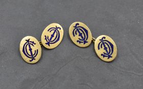 A pair of yellow metal cufflinks stamped 18ct, of oval form bearing blue enamel monograms, with