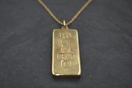 A 9ct gold ingot pendant having over sized hallmark decoration with 9ct gold chain, approx 34.1g