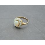 An oval opal cluster ring in a stepped claw mount on a 9ct gold loop, size R & approx 1.7g