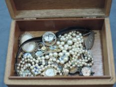 A small wooden jewellery box containing a small selection of costume jewellery including Ciro pearls