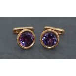 A pair of yellow metal cufflinks stamped 14A having facet cut heat treated amethyst stones and bar