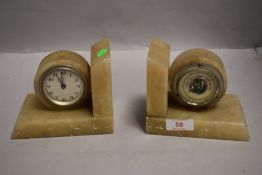 A pair of Art Deco polished stone book ends, having clock and barometer dials