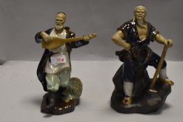 Two 20th century Chinese Mudmen figures one playing guitar and another holding axe