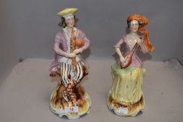 Two Victorian Staffordshire flat back figures of folk musicians one playing a flute and similar with