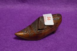 An antique snuff container in the form of a Georgian clog with slide lid and carved detail reading