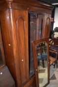 A Victorian mahogany mirror door wardrobe having drawer base