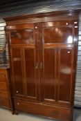 An early 20th Century double wardrobe/linen press having dental cornice, blind fret frieze, fitted